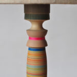 detail of wooden table lamp with cotton reel motif